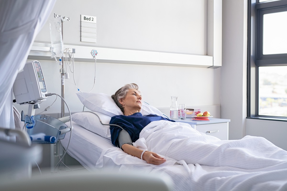 older_woman_in_hospital_bed_looking_out_window